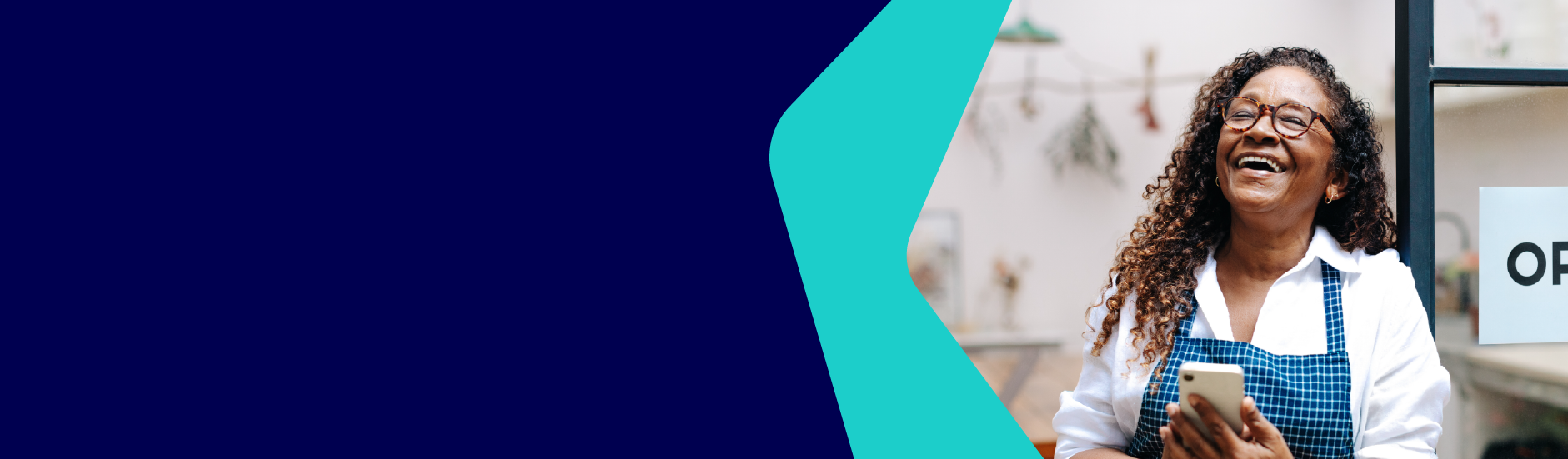 mulher em local de trabalho sorrindo com celular na mão