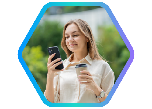 mulher sorrindo segurando celular em uma m�o e copo de caf� em outra.